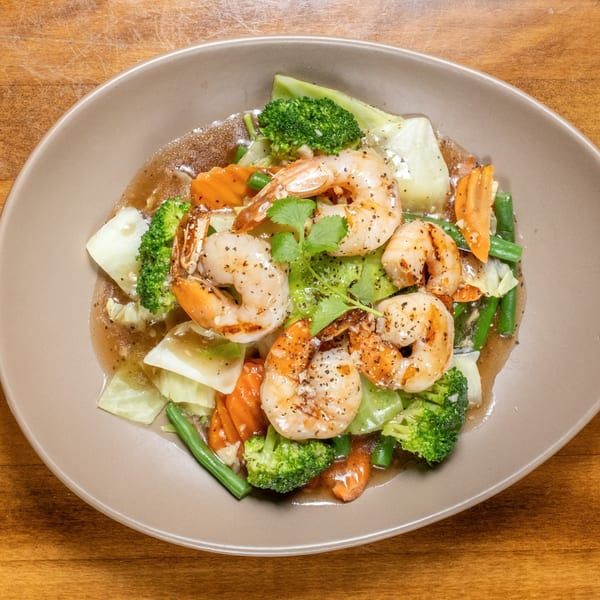 Thai stir-fried shrimp with broccoli, carrots, green beans, and cabbage in a savory sauce.